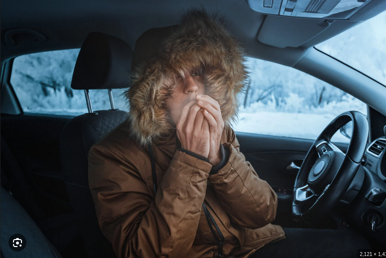 Frozen hands near a dash vent needing heat
